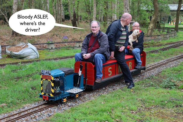 A group of men riding a small train

Description automatically generated with low confidence